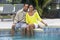 African American Couple Sitting By A Swimming Pool