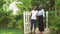 A African american couple is walking through a fence into a new house. They look very excited and happy.