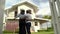 A African american couple is walking through a fence into a new house. They look very excited and happy.