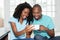 African american couple watching tv online on phone