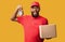 African American Courier Holding Clock Delivering Cardboard Box, Studio Shot