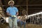 African American cow breeder standing in outdoor cowshed