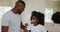 African american daughter brushing teeth and talking with her father