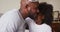 African American daughter and father wearing crown hugging each other at home