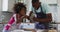 African american daughter and her father making pizza together in kitchen