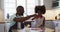 African american daughter and her father making pizza together in kitchen