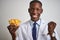 African american doctor man holding bowl with macaroni pasta over  white background screaming proud and celebrating