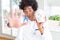 African American doctor man holding skull with open hand doing stop sign with serious and confident expression, defense gesture