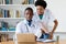 African american doctor with nurse looking at computer