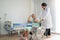 african american doctor is pushing the wheelchair And provide consultation regarding treatment to patients sitting in a