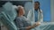 African american doctor talking to elder sick patient