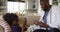 African american doctor using digital tablet and talking to sick girl at home