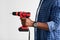 African american driller man with electric screwdriver, ready to repair home furniture, white background, side view