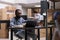 African american employee sitting at desk in warehouse delivery department looking at cargo stock on laptop