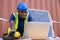 African american engineer and caucasian electrician wearing blue hard hat working on laptop computer