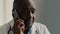 African American ethnic doctor man therapist medical worker consult patient by mobile phone male professional adviser