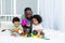 African-American family dad with kids babies play and collect a colorful pyramid at home on the bed, happy family