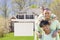 African American Family In Front of Blank Real Estate Sign and H