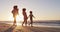 African american family having fun walking together during sunset on the beach