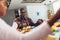 African-American family saying grace at dinner table and holding hands