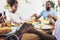 African-American family saying grace at dinner table and holding hands