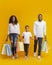 African American family of three walking with shopping bags in studio