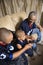 African-American family watching tv with boy holding remote.