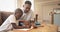 African American father helping his son with homework at table