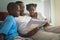 African American father with his children reading a storybook on bed in bedroom