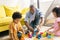 african american father and kids playing with colorful blocks on floor together