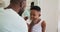 African American father putting shaving cream on his son mouth and laughing together