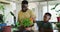 African american father and son watering plant pot together at home