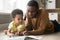 African American father and toddler son reading book together