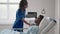 An African-American female doctor comes to the patient and asks about his condition and conducts an examination