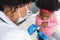 African american female doctor wearing face mask vaccinating girl patient at hospital