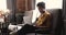 African American female freelancer work on laptop sitting in armchair