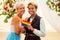 African american female groom in black suit and happy caucasian blonde bride loving together on beach ceremony under