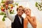 African american female groom in black suit and happy caucasian blonde bride loving together making selfie photo on