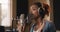 African american female musician in headphones singing song to mic at sound record studio, slow motion