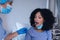 African american female patient with mouth open tested with swab test by female doctor in face mask