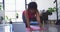African american female plus size with laptop kneeling on exercise mat working out