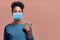 African American Female Wearing Respiratory Mask Shows Something at Blank Space