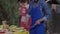 African American focused man cleaning spatula with fork standing on picnic at barbecue grill. Camera moves down as