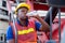 African American foreman or container worker drink water with close his eye and sit to relax on crane truck