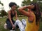 African american friend helping to support her friend doing sit-ups in the park - female friends doing exercise outdoors