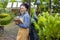 African American gardener holding clipboard while working in her conifer tree nursery garden center for evergreen and bonsai