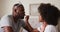 African american girl applying lipstick to her father father wearing crown at home