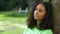 African American girl biracial teenager young woman outside sad or depressed sitting leaning against a tree