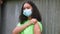 African American girl biracial teenager young woman outside wearing a face mask and showing her vaccine sticking plaster during CO