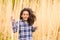 African american girl in checked shirt outdoors in field.